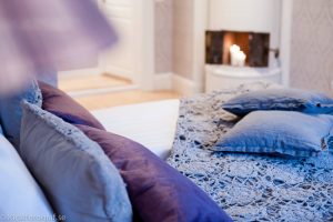 Hotellrum i Trädgårdsmästarvillan, lila kuddar och överkast
